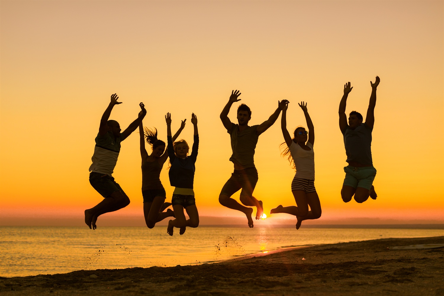 Gute Weiterbildung - Menschen springen vor Sonnenuntergang